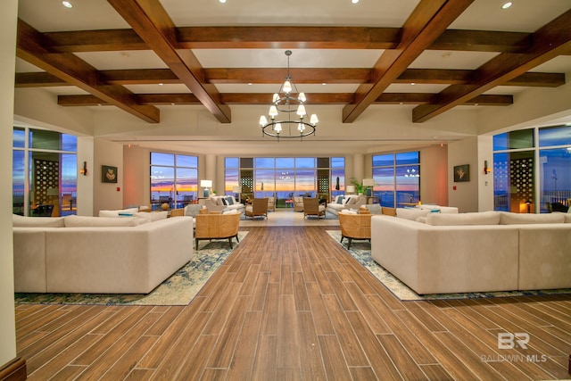 living room featuring wood-type flooring, beamed ceiling, a chandelier, and coffered ceiling