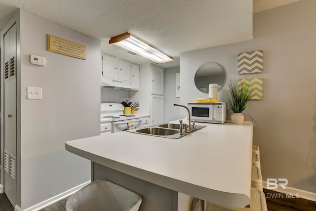 kitchen featuring a kitchen breakfast bar, white cabinets, white appliances, kitchen peninsula, and sink