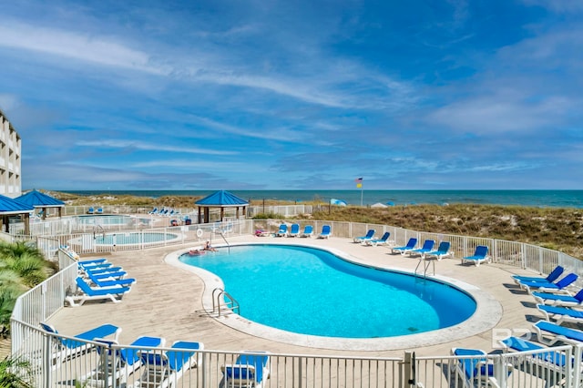 view of swimming pool with a water view and a patio