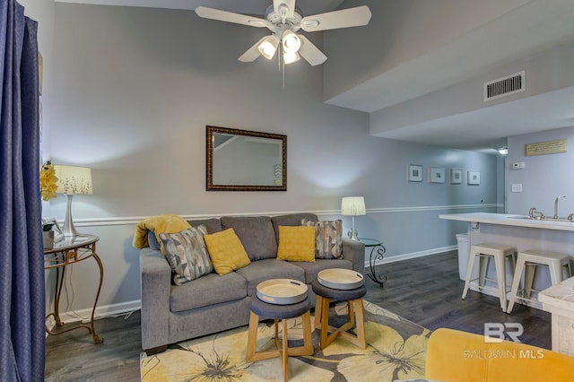 living room featuring hardwood / wood-style floors, ceiling fan, and sink