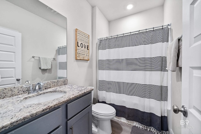 bathroom featuring a shower with curtain, vanity, toilet, and wood finished floors