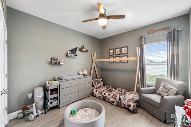 bedroom with wood finished floors, a ceiling fan, and baseboards