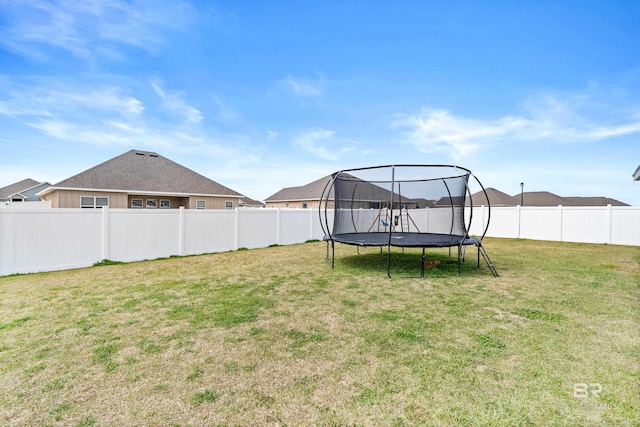 view of yard featuring a trampoline and a fenced backyard