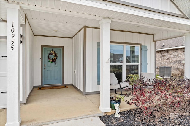 view of exterior entry with a porch, board and batten siding, and central air condition unit