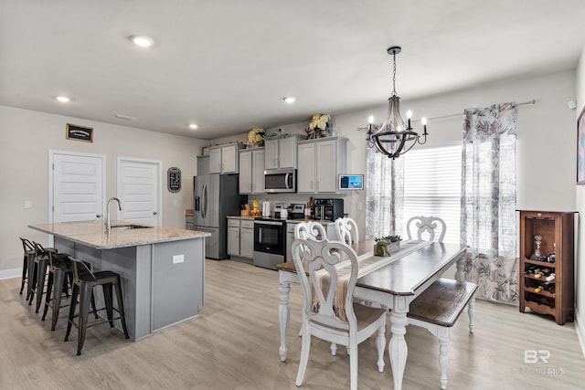 dining room featuring light wood-type flooring, a chandelier, and recessed lighting