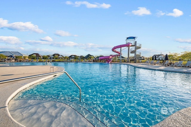 pool with a water slide and a residential view