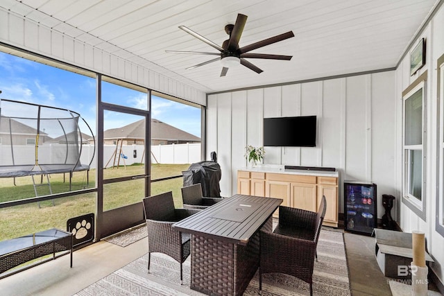 sunroom / solarium featuring ceiling fan and wine cooler