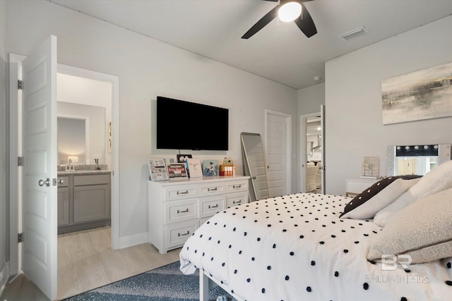 bedroom featuring connected bathroom, light wood-style flooring, ceiling fan, and baseboards