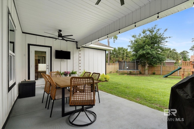 view of patio / terrace featuring a trampoline, ceiling fan, a playground, and outdoor dining area