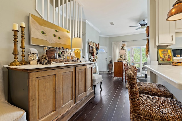 kitchen featuring ceiling fan, crown molding, and dark wood-type flooring