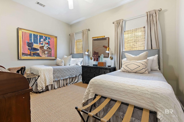 carpeted bedroom with ceiling fan, multiple windows, and visible vents