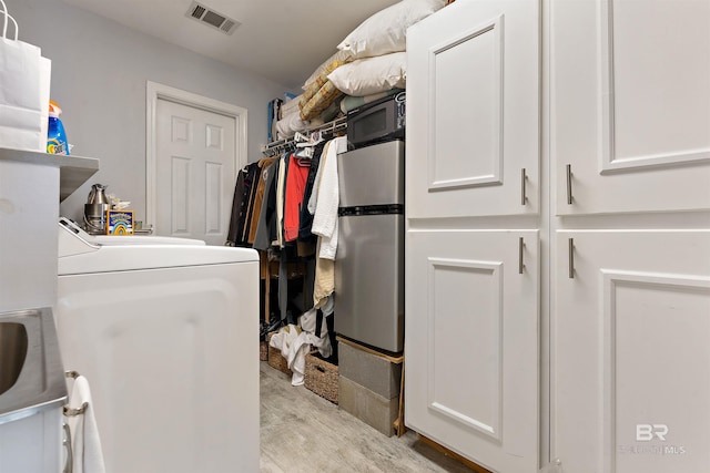 clothes washing area with light wood-type flooring