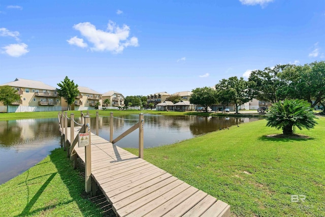 view of dock with a yard, a water view, and a residential view