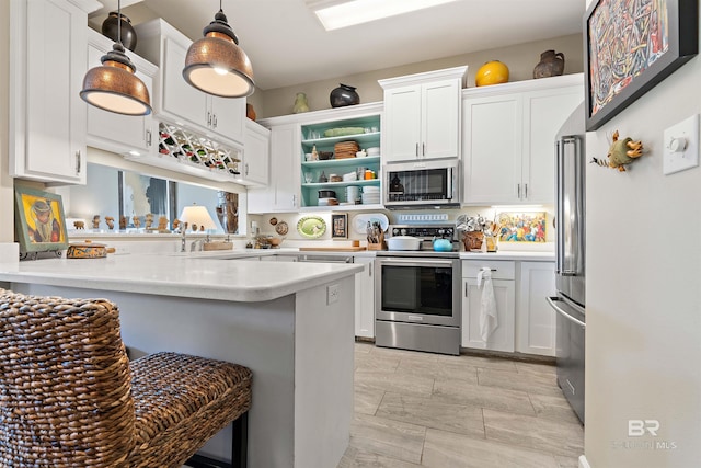 kitchen featuring appliances with stainless steel finishes, hanging light fixtures, white cabinets, and light tile floors