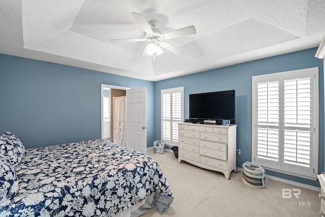 bedroom featuring carpet, a raised ceiling, a ceiling fan, a textured ceiling, and baseboards