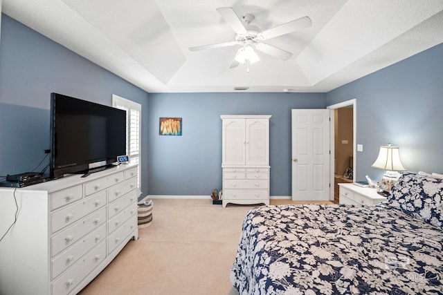 bedroom with baseboards, a tray ceiling, ceiling fan, and light colored carpet