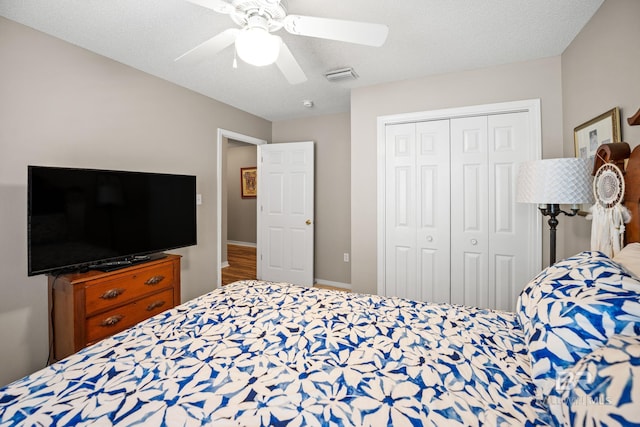 bedroom with baseboards, visible vents, ceiling fan, a textured ceiling, and a closet