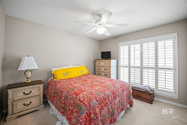 bedroom featuring a textured ceiling, carpet floors, multiple windows, and baseboards