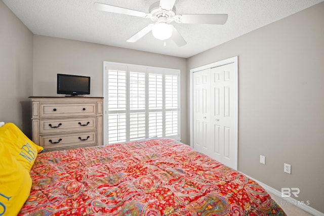 bedroom with a textured ceiling, ceiling fan, a closet, and baseboards