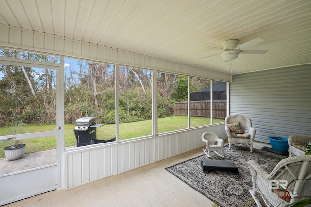 sunroom / solarium featuring a ceiling fan