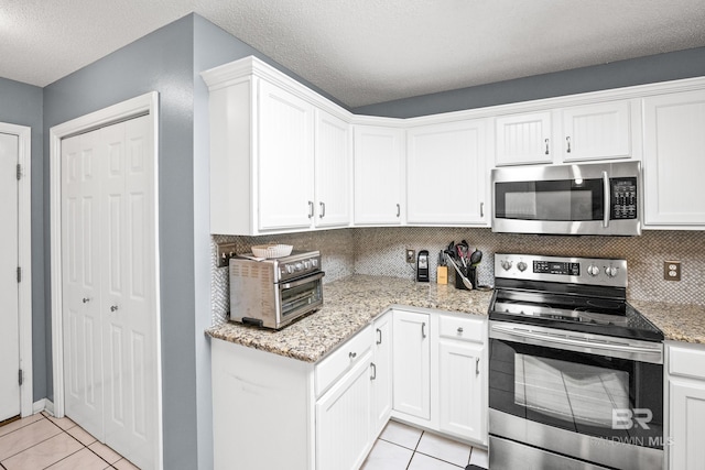 kitchen featuring light tile patterned floors, white cabinetry, and appliances with stainless steel finishes