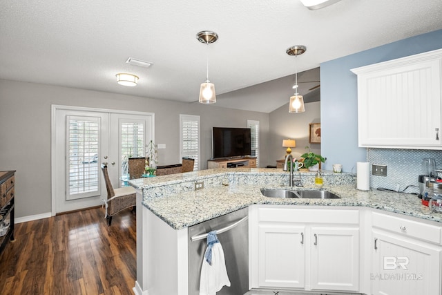 kitchen with a peninsula, a sink, white cabinets, stainless steel dishwasher, and french doors