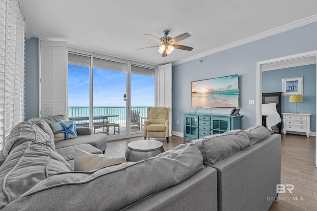 living room with floor to ceiling windows, ceiling fan, crown molding, wood finished floors, and baseboards