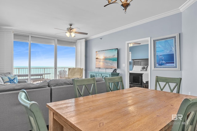 dining space with crown molding, expansive windows, and a ceiling fan