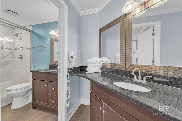 full bath featuring a stall shower, crown molding, wood finished floors, vanity, and toilet