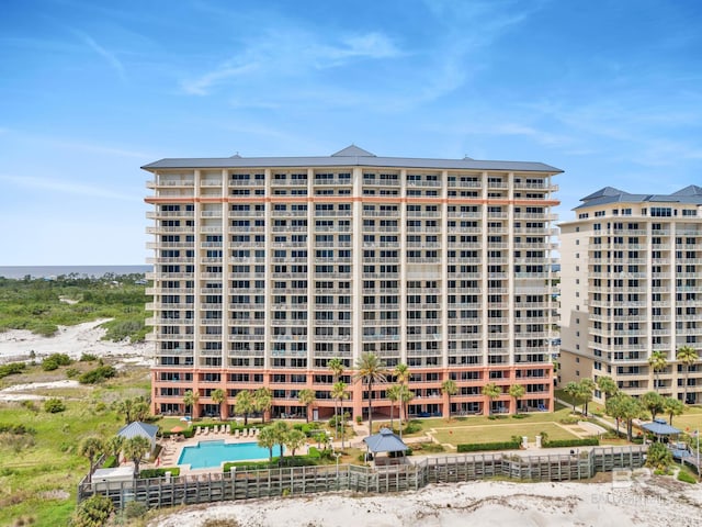view of apartment building / complex featuring a community pool and fence