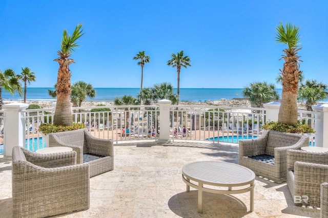 view of patio with a water view and a community pool