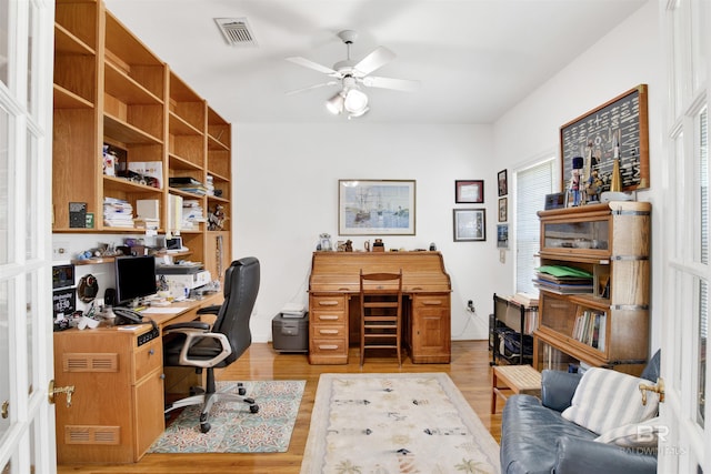 office area featuring light wood-style floors, visible vents, and a ceiling fan