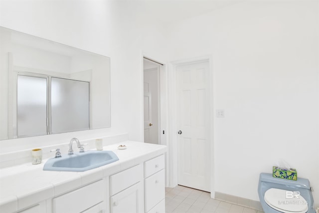 bathroom featuring tile patterned flooring, baseboards, vanity, and toilet