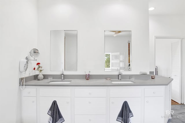 full bath featuring double vanity, a sink, and wood finished floors