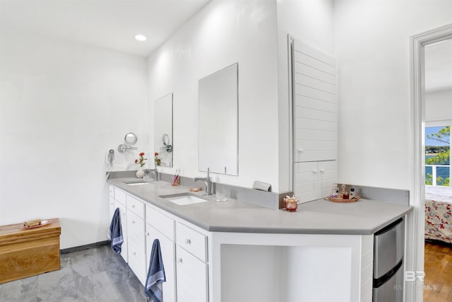 laundry area featuring baseboards, a sink, and recessed lighting