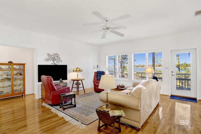 living area featuring a ceiling fan, visible vents, and light wood-style flooring