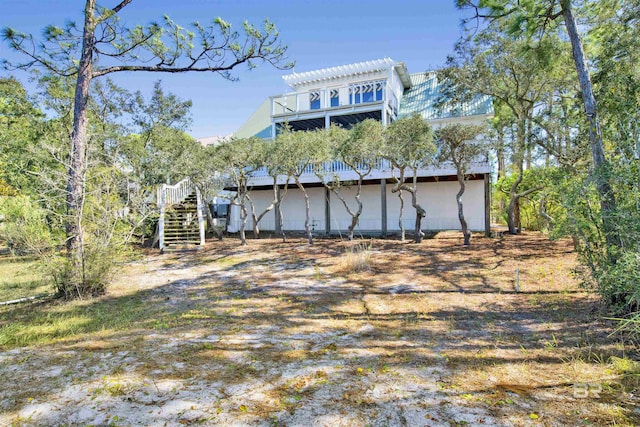 rear view of house featuring stairway and a pergola