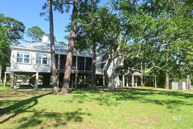 9397 S Bay Rd, Foley, AL 36535 - rear view of house featuring a chimney, a sunroom, stairway, and a yard