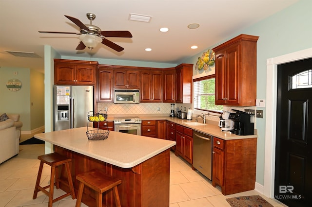 9397 S Bay Rd, Foley, AL 36535 - kitchen with a sink, backsplash, a breakfast bar, appliances with stainless steel finishes, and ceiling fan