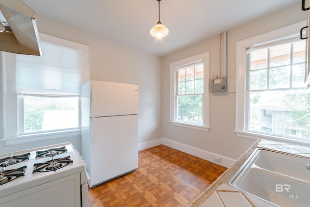 kitchen with a wealth of natural light, light parquet flooring, pendant lighting, and white appliances