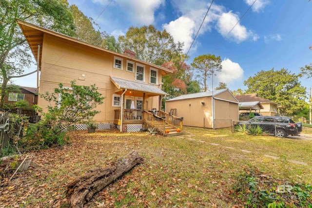 rear view of property with a yard and an outbuilding