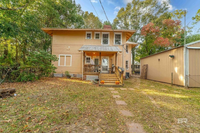 rear view of property with a porch, a yard, and central AC unit