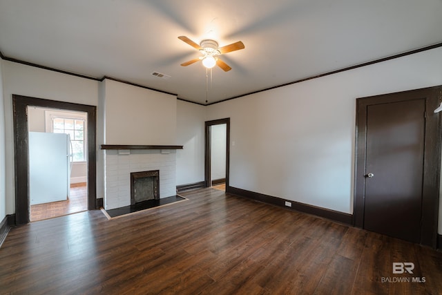 unfurnished living room with ornamental molding, ceiling fan, a fireplace, and dark hardwood / wood-style flooring