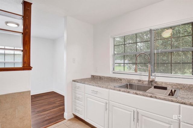 kitchen featuring white cabinetry, light hardwood / wood-style flooring, and sink