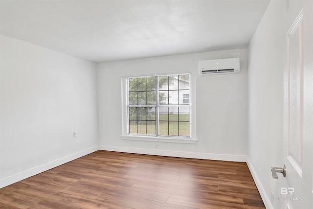 empty room with an AC wall unit and dark hardwood / wood-style flooring