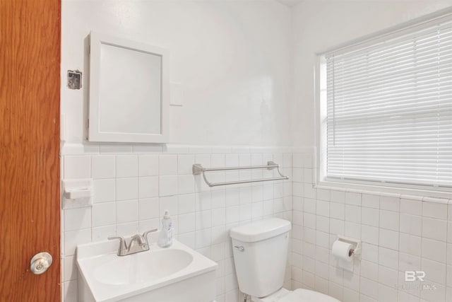 bathroom featuring tile walls, vanity, and toilet