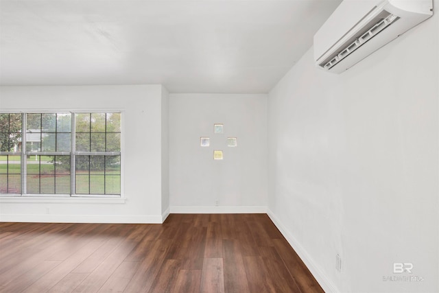 empty room featuring a wall mounted AC and dark wood-type flooring