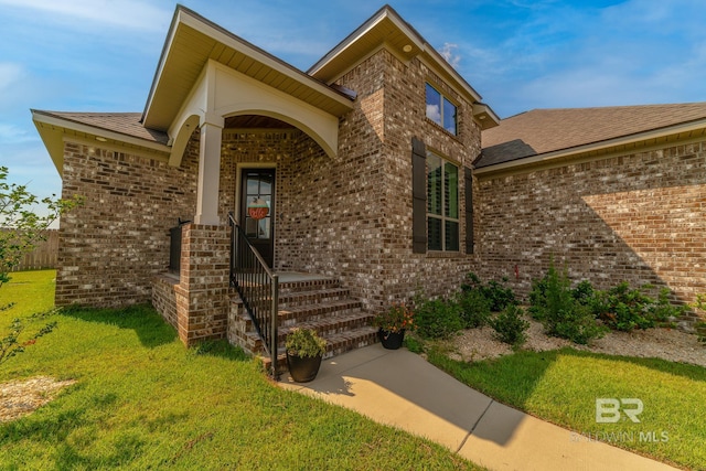 view of exterior entry featuring a yard