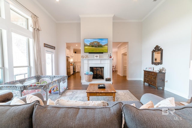 living room featuring a healthy amount of sunlight, crown molding, and dark wood-type flooring