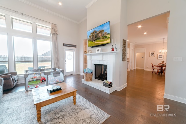 living room with a fireplace, ornamental molding, dark hardwood / wood-style floors, and a healthy amount of sunlight